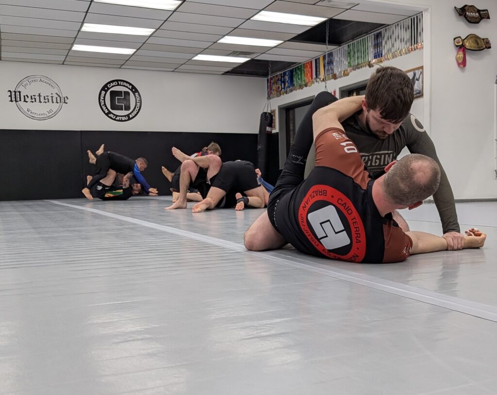 students grouped in pairs in different spots on the mats training nogi jiu jitsu